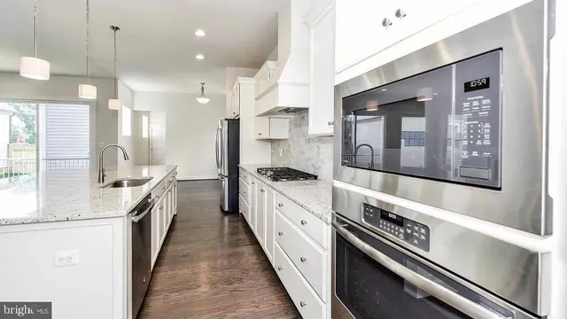 a large kitchen with stainless steel appliances lots of counter space and a sink