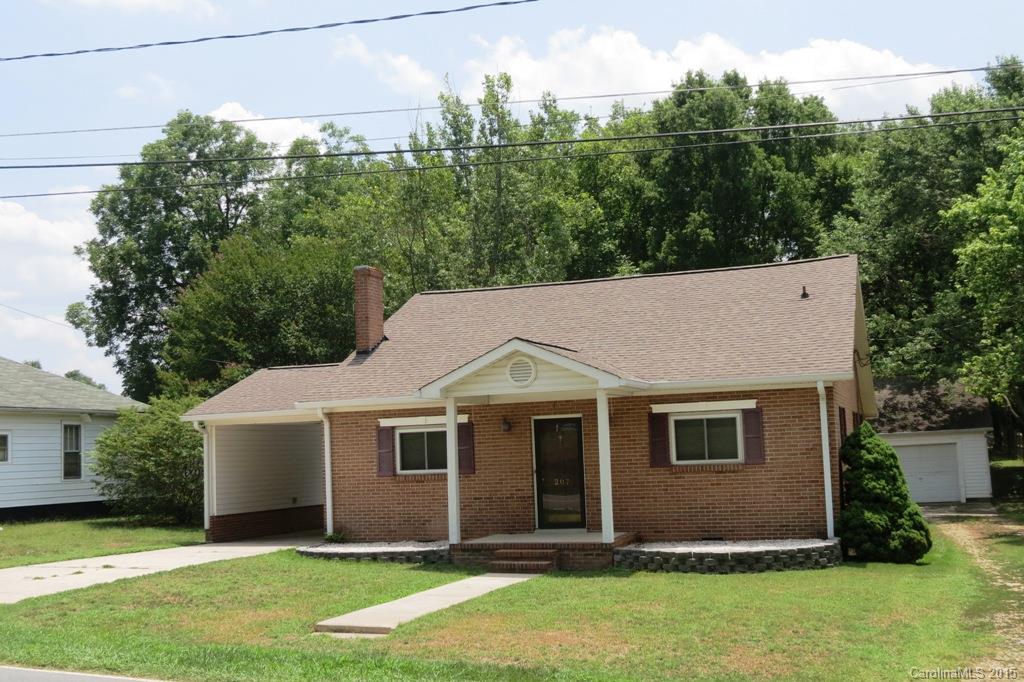 a aerial view of a house next to a yard and large trees