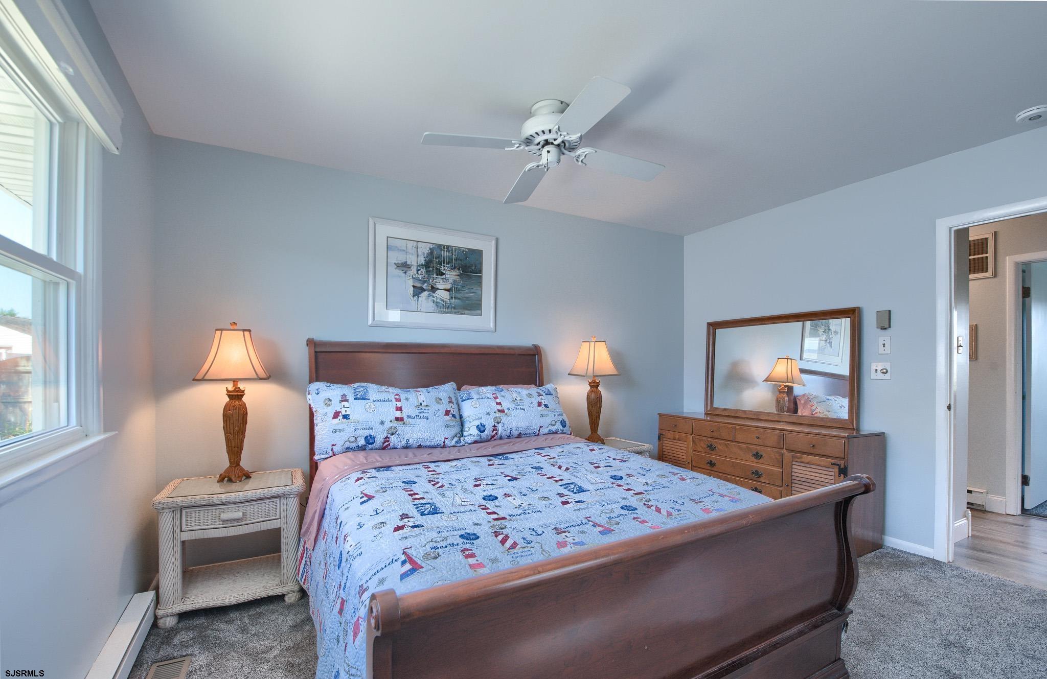 2 Surf Lane Brigantine, NJ 08203 - Photo 18 of 42 a bedroom with a bed and a lamp with window
