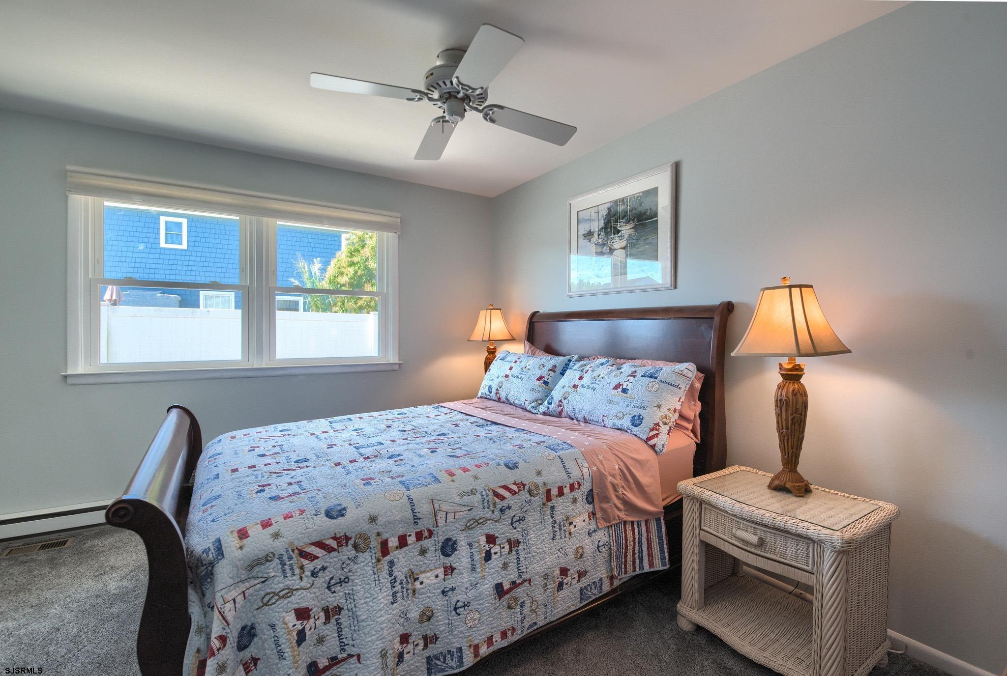 2 Surf Lane Brigantine, NJ 08203 - Photo 19 of 42 a bedroom with a bed and a lamp on dresser