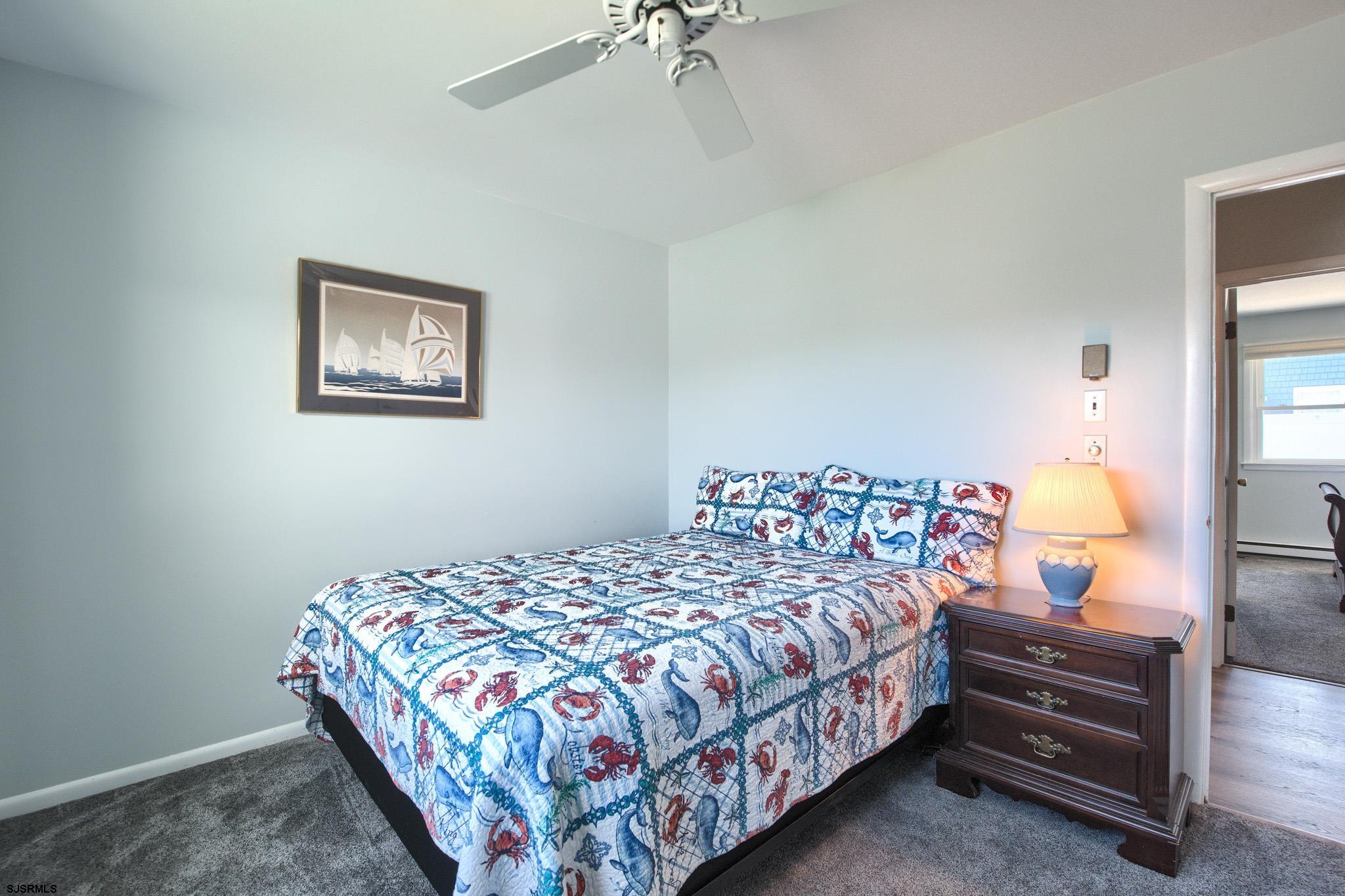2 Surf Lane Brigantine, NJ 08203 - Photo 23 of 42 a bedroom with a bed and a chandelier