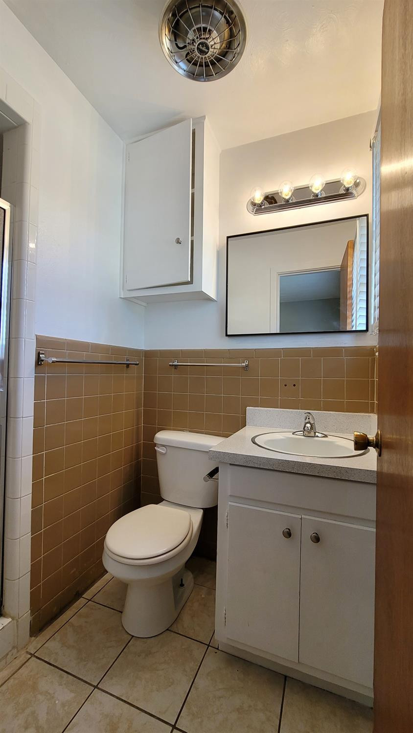 5430 13th Street Lubbock, TX 79416 - Photo 12 of 26 a bathroom with a toilet sink and mirror