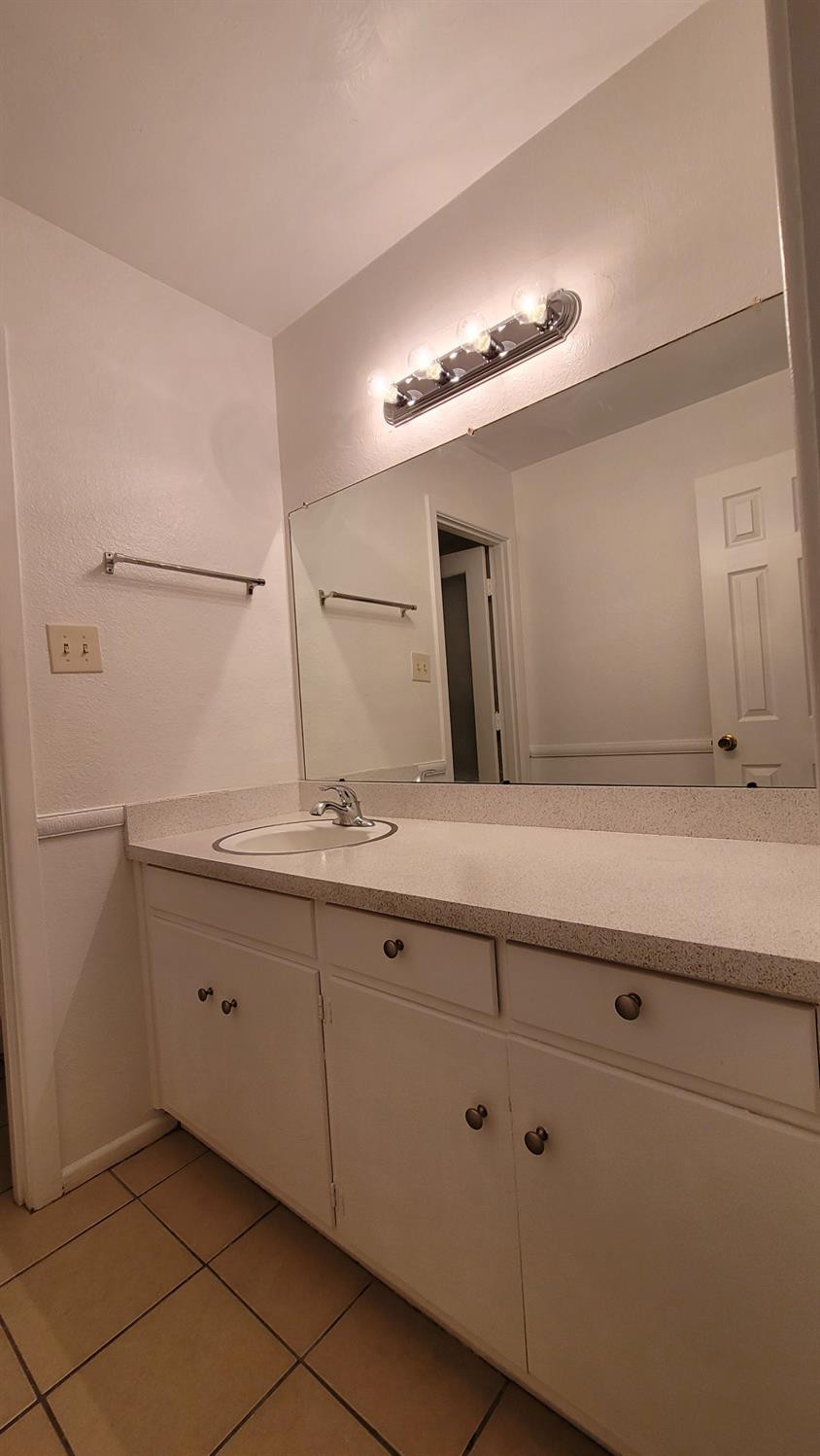 5430 13th Street Lubbock, TX 79416 - Photo 13 of 26 a bathroom with a double vanity sink and a mirror