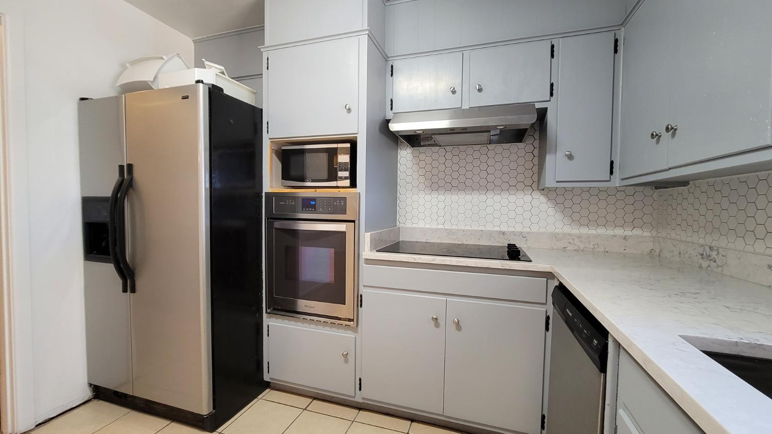 5430 13th Street Lubbock, TX 79416 - Photo 19 of 26 a kitchen with a refrigerator sink and cabinets