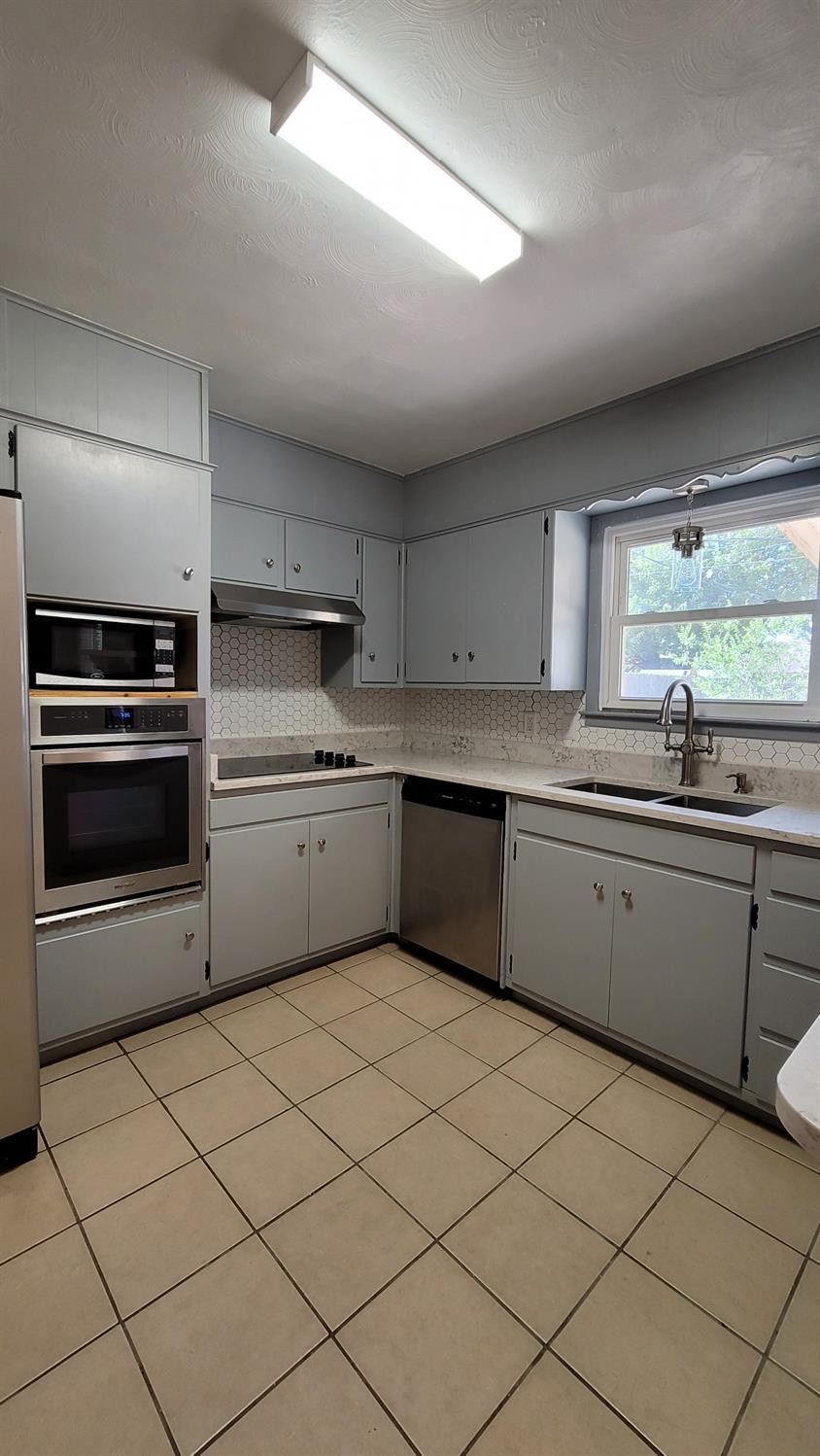 5430 13th Street Lubbock, TX 79416 - Photo 20 of 26 a kitchen with a sink cabinets and stainless steel appliances