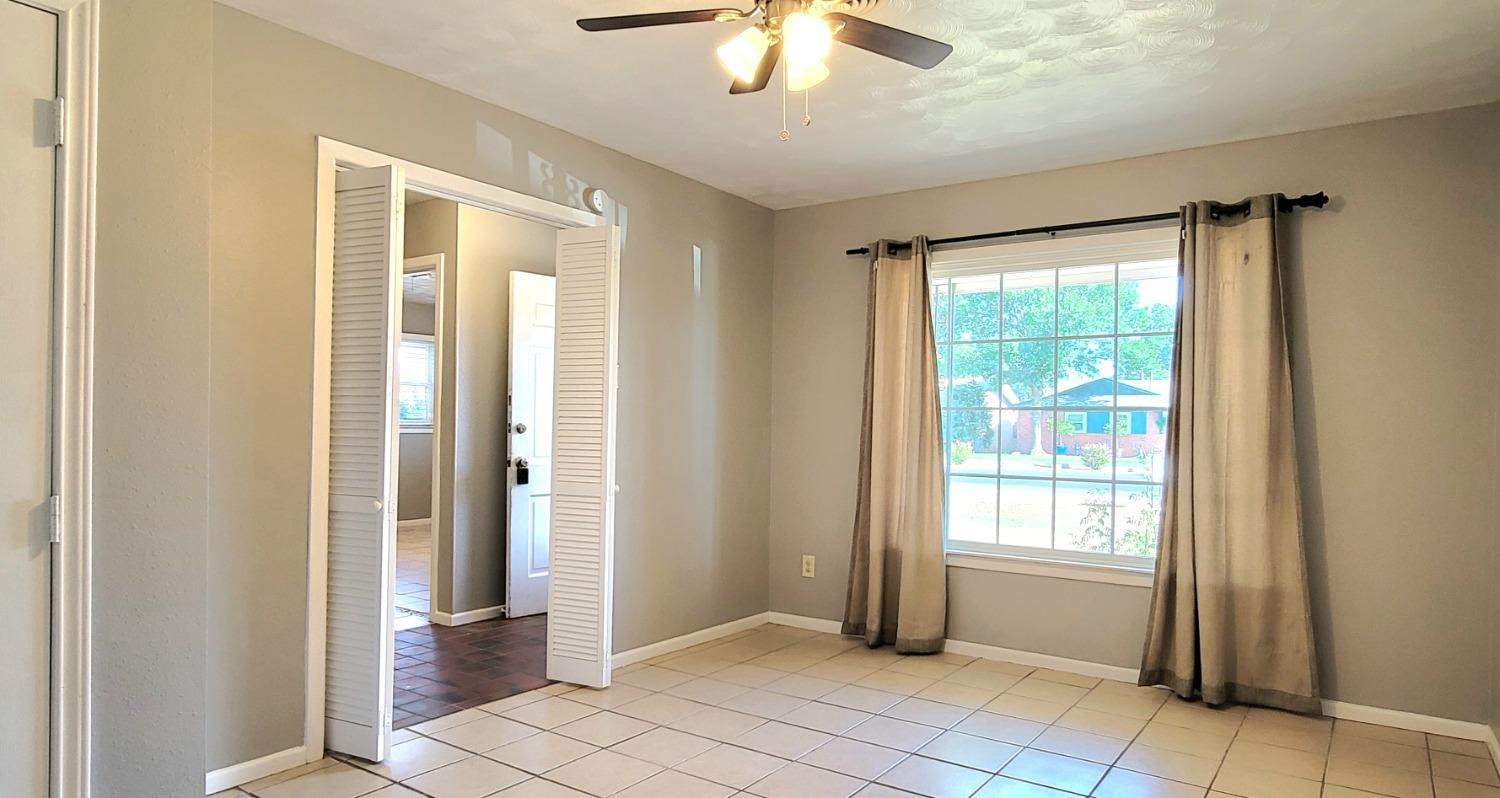 5430 13th Street Lubbock, TX 79416 - Photo 3 of 26 a view of an empty room with window and chandelier fan