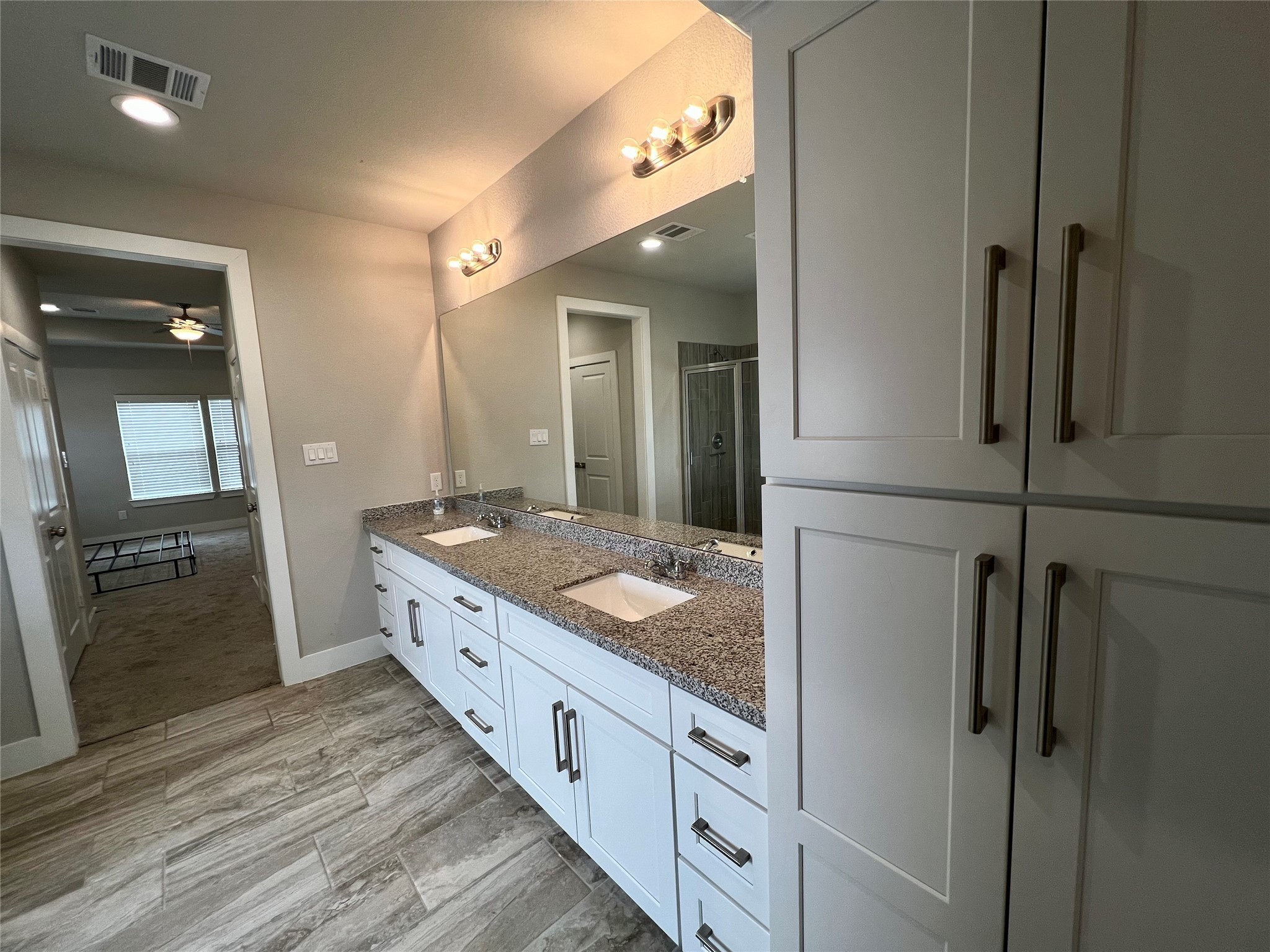 4301 Clover Street Houston, TX 77051 - Photo 20 of 32 a bathroom with a granite countertop sink a mirror and shower