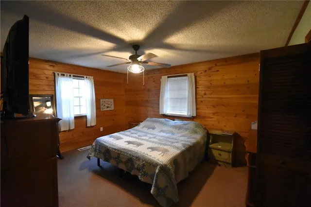 a bedroom with a bed table closet and flat screen tv