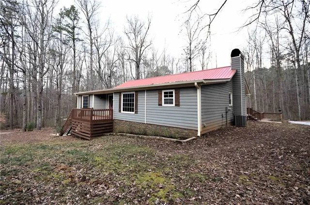 a view of a barn in the backyard with large tree