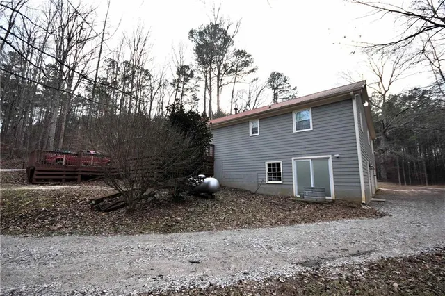 a view of a house with a yard and large tree