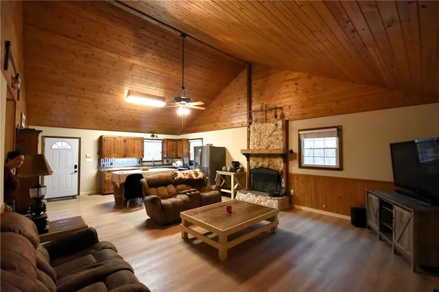 a living room with furniture a flat screen tv and kitchen view