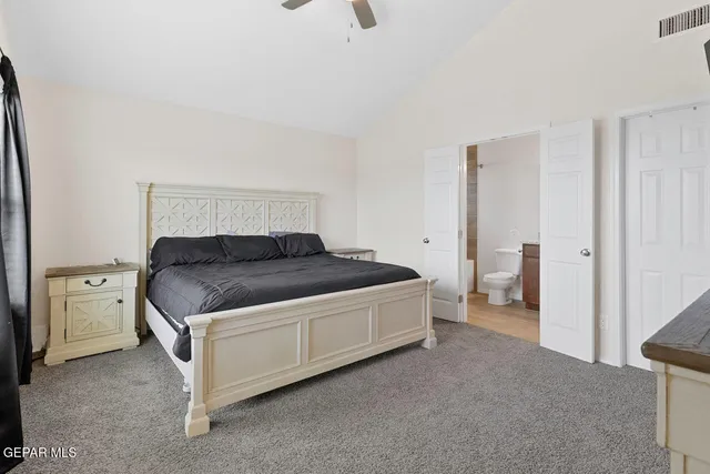 a spacious bedroom with a bed and a cabinets