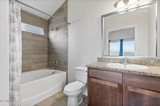a bathroom with a granite countertop sink toilet mirror and bathtub