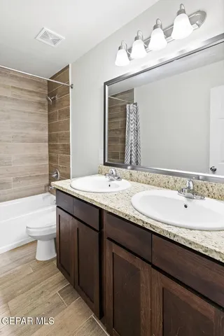 a bathroom with a granite countertop sink a toilet and bathtub