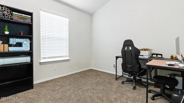 a view of a workspace with furniture and a window