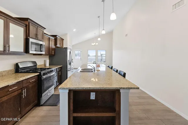 a kitchen with stainless steel appliances granite countertop a sink a stove and a microwave