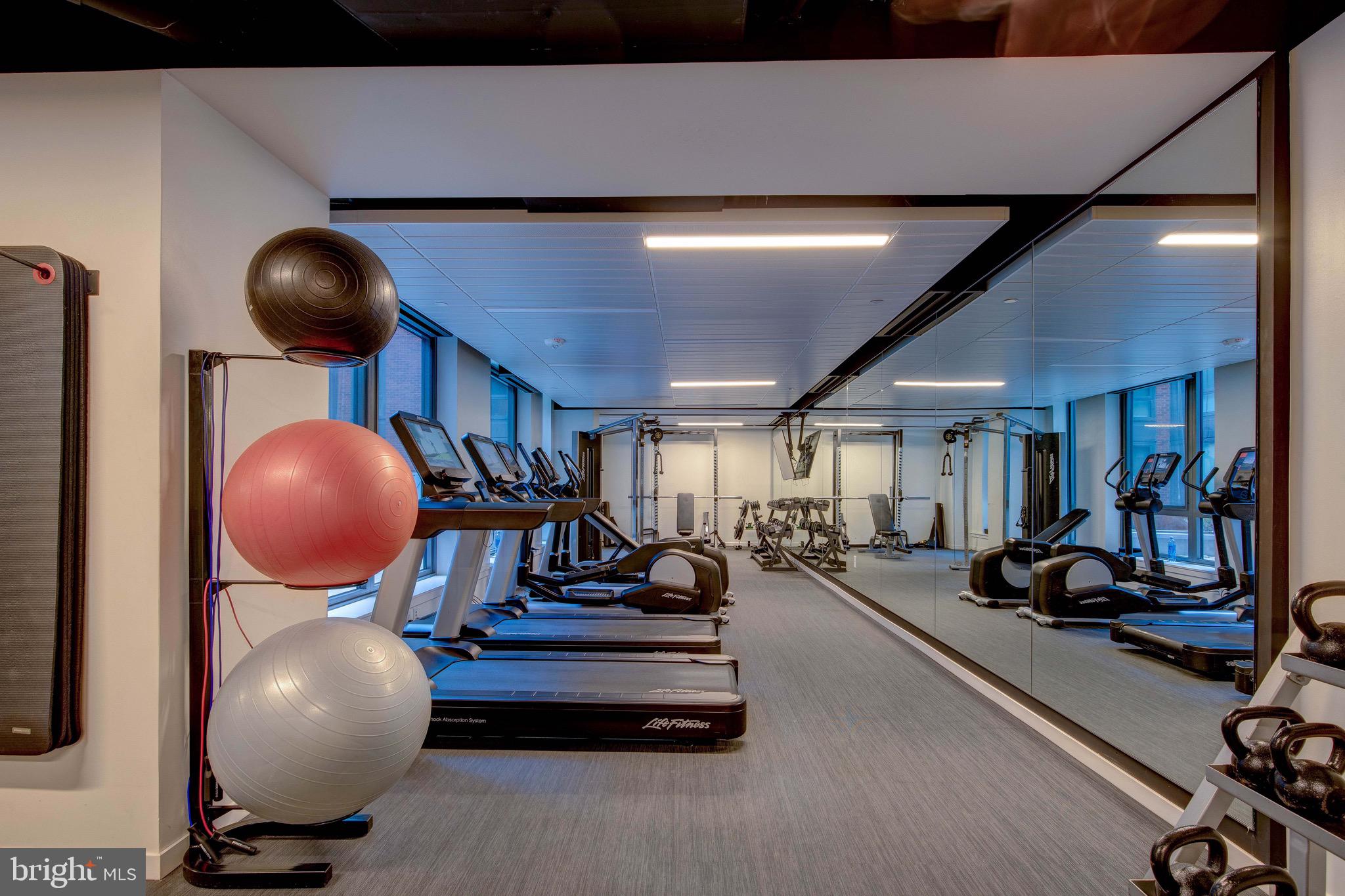 1211 Van Street Southeast, Unit 1210 Washington, DC 20003 - Photo 33 of 42 a room with wooden floor and gym equipment