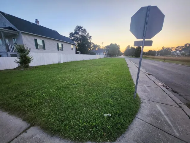 a front view of a house with a yard and trees