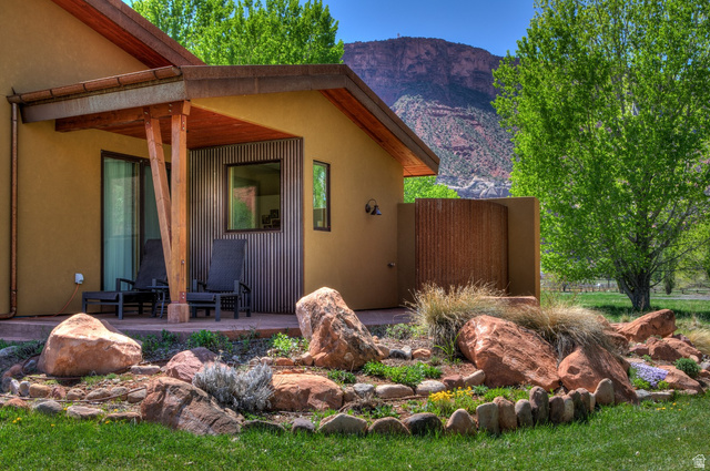425 Amber Lane Moab, UT 84532 - Photo 24 of 27 View of side of home featuring a mountain view, a patio, and stucco siding