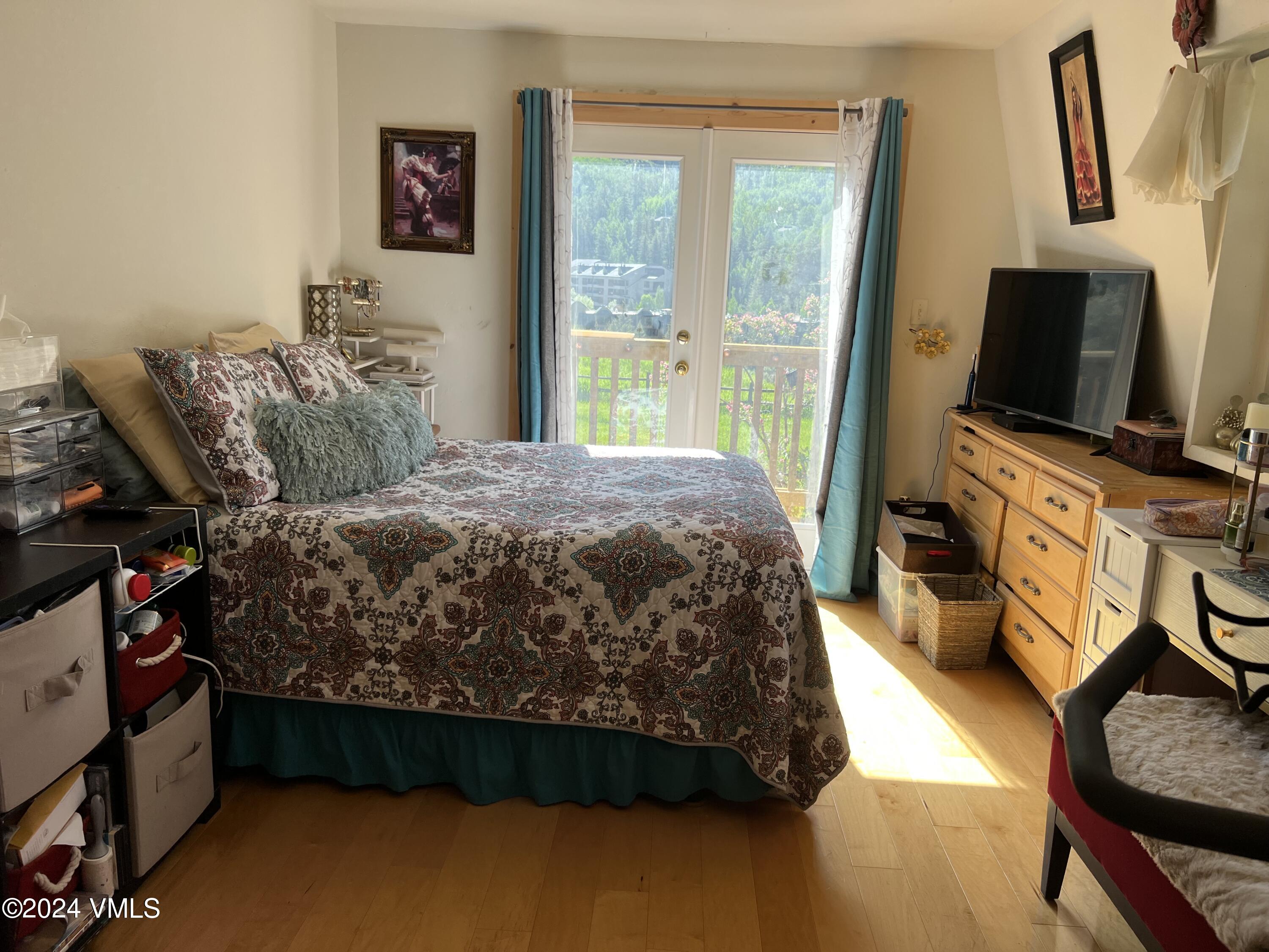 2450 Chamonix Lane, Unit 4 Vail, CO 81657 - Photo 4 of 7 a bedroom with a bed and flat tv screen on the dresser