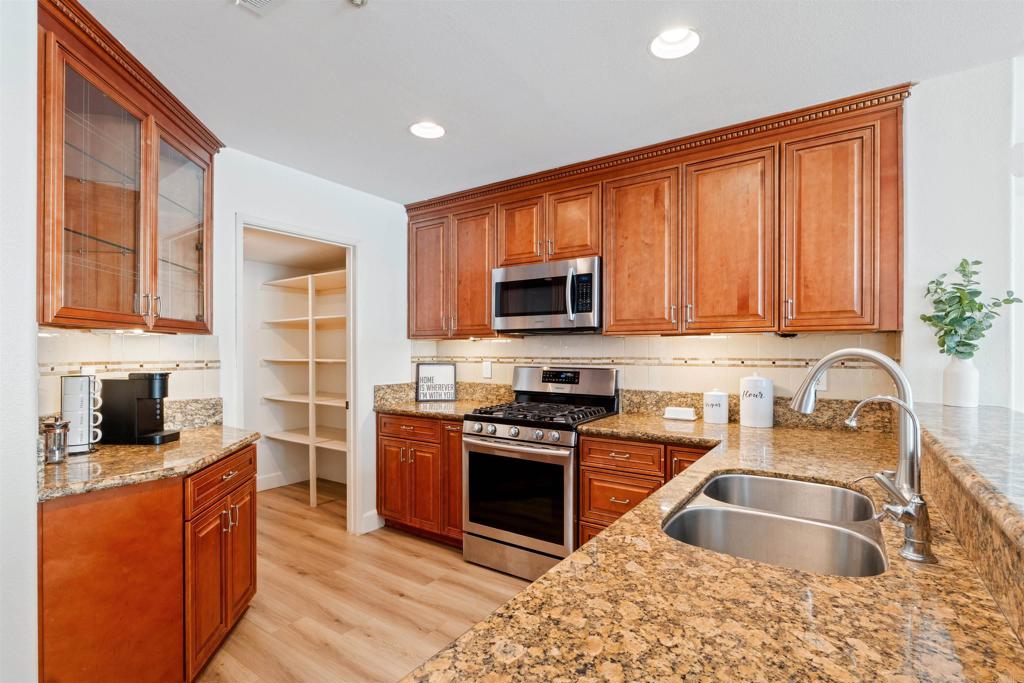 1831 Monserrat Way Vista, CA 92081 - Photo 12 of 46 a kitchen with stainless steel appliances granite countertop a sink stove and refrigerator