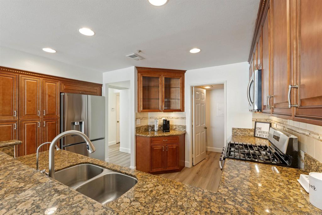1831 Monserrat Way Vista, CA 92081 - Photo 14 of 46 a kitchen with a sink and a stove top oven