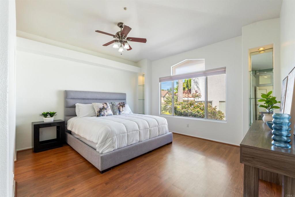 1831 Monserrat Way Vista, CA 92081 - Photo 19 of 46 a bedroom with a large bed and a chandelier fan