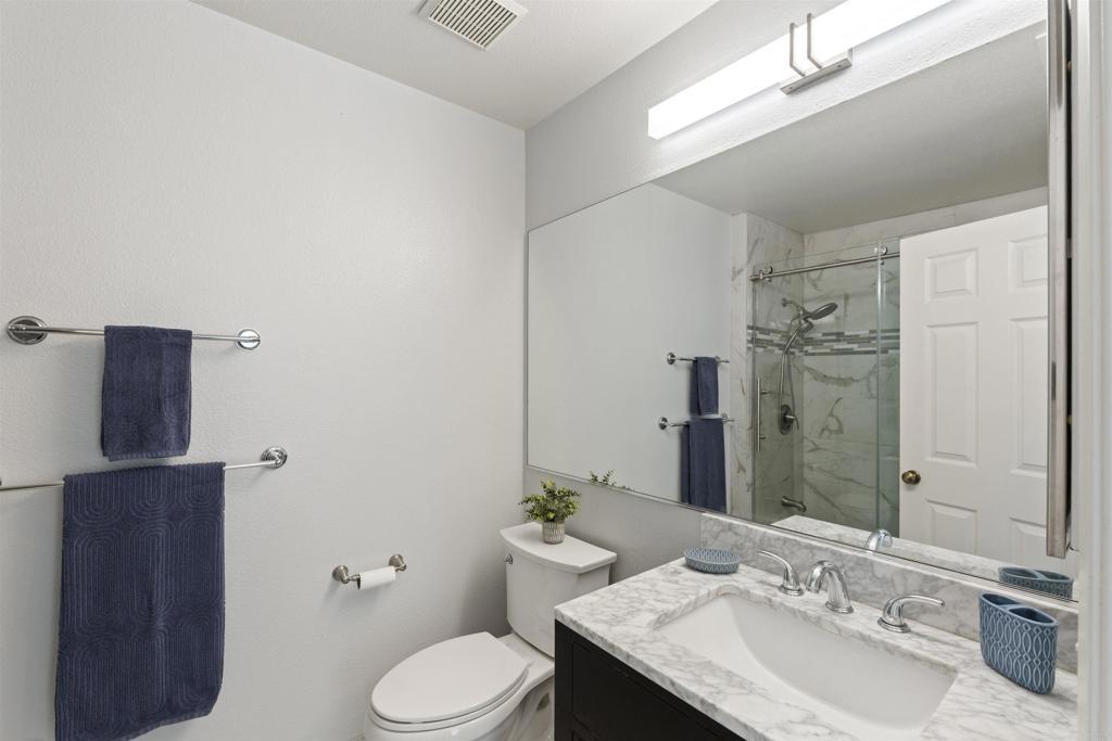 1831 Monserrat Way Vista, CA 92081 - Photo 28 of 46 a bathroom with a granite countertop sink toilet and shower