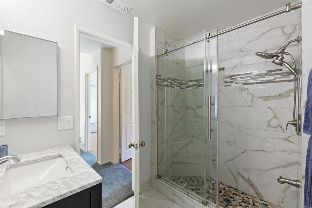 1831 Monserrat Way Vista, CA 92081 - Photo 29 of 46 a bathroom with a granite countertop sink and shower