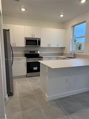 a kitchen with stainless steel appliances granite countertop a stove a refrigerator and a sink