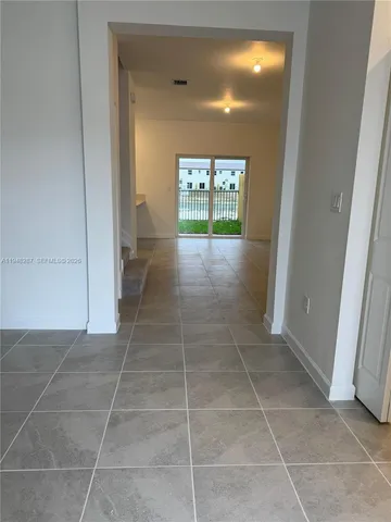 a view of hallway with a door and a rug