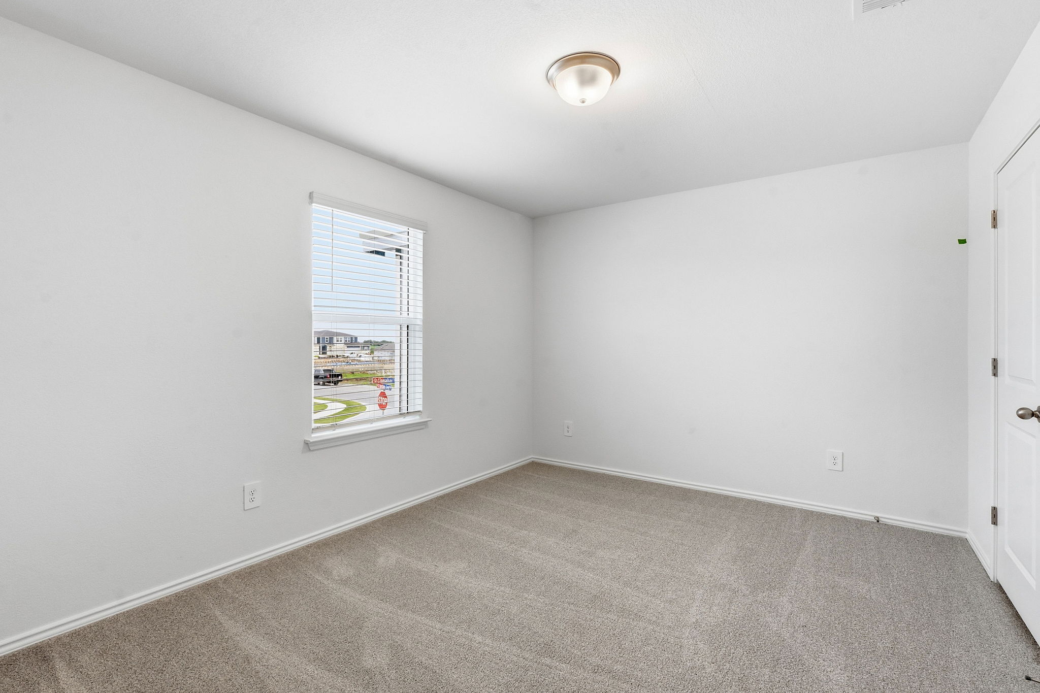 164 Cinnabar Lane, Unit 4 Kyle, TX 78640 - Photo 18 of 23 Room featuring neutral carpeting, white painted walls, and a single window with blinds