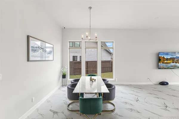 a view of a dining room with furniture chandelier and a window