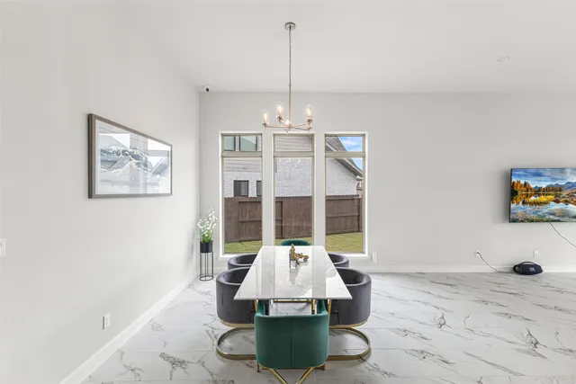 a view of a dining room with furniture chandelier and a window