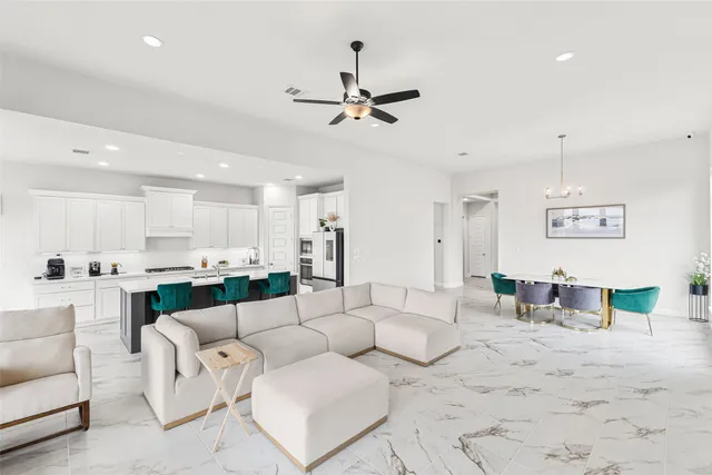 a living room with furniture kitchen view and a chandelier