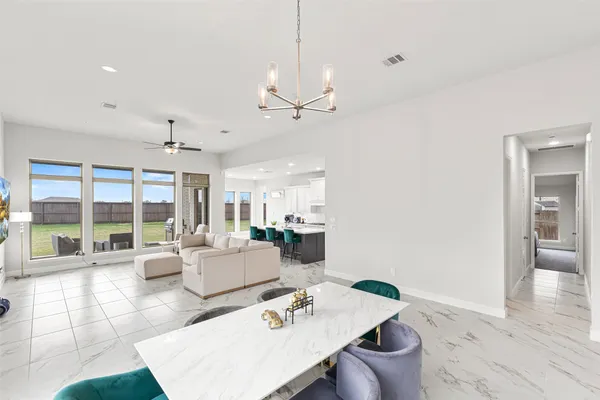 a living room with furniture a large window with kitchen view
