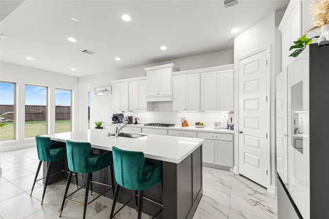 a kitchen with a sink and chairs