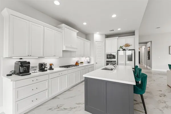 a kitchen with white cabinets and white appliances