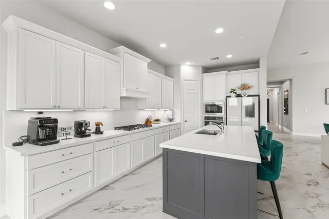 a kitchen with white cabinets and white appliances