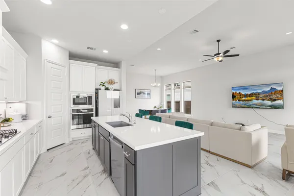 a kitchen that has a lot of cabinets in it and wooden floors