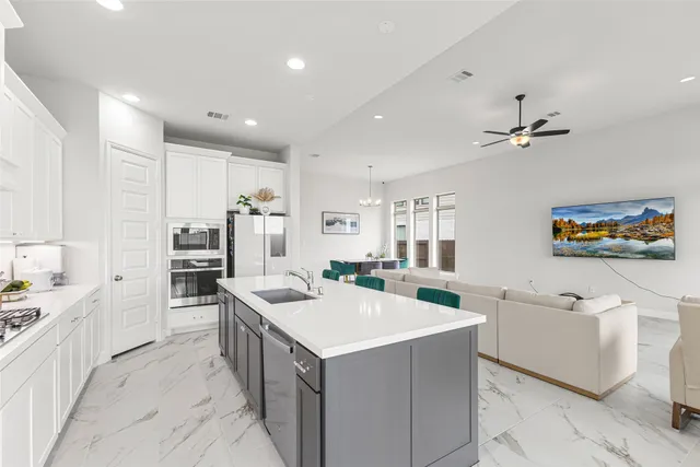 a kitchen that has a lot of cabinets in it and wooden floors
