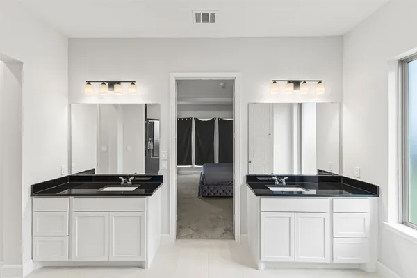a kitchen with a refrigerator and white cabinets