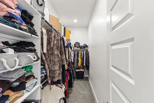 a view of walk in closet with clothes