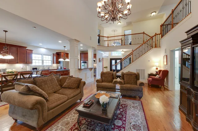 a living room with furniture a chandelier and a dining table