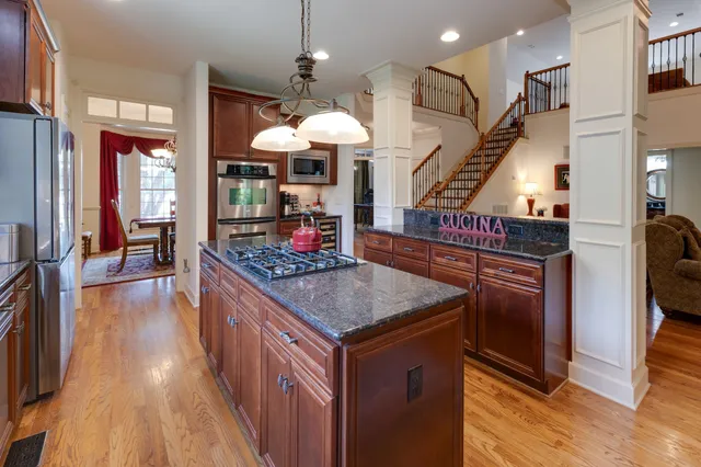 a kitchen with stainless steel appliances granite countertop a stove and a wooden floors