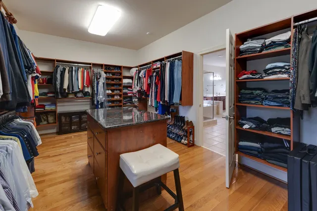 a view of walk in closet with clothes and shoes