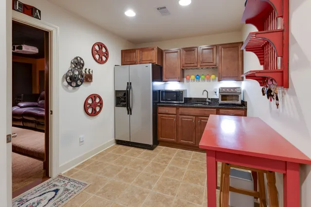 a kitchen with a refrigerator and a stove top oven