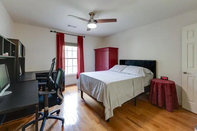 a bedroom with a bed tv and a window