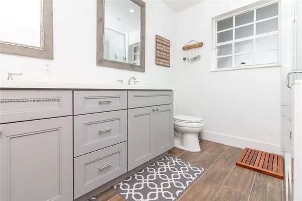 a spacious bathroom with a double vanity sink a mirror and a
