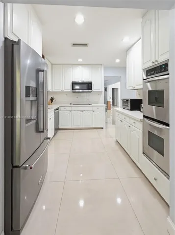 a kitchen with stainless steel appliances a refrigerator sink and cabinets